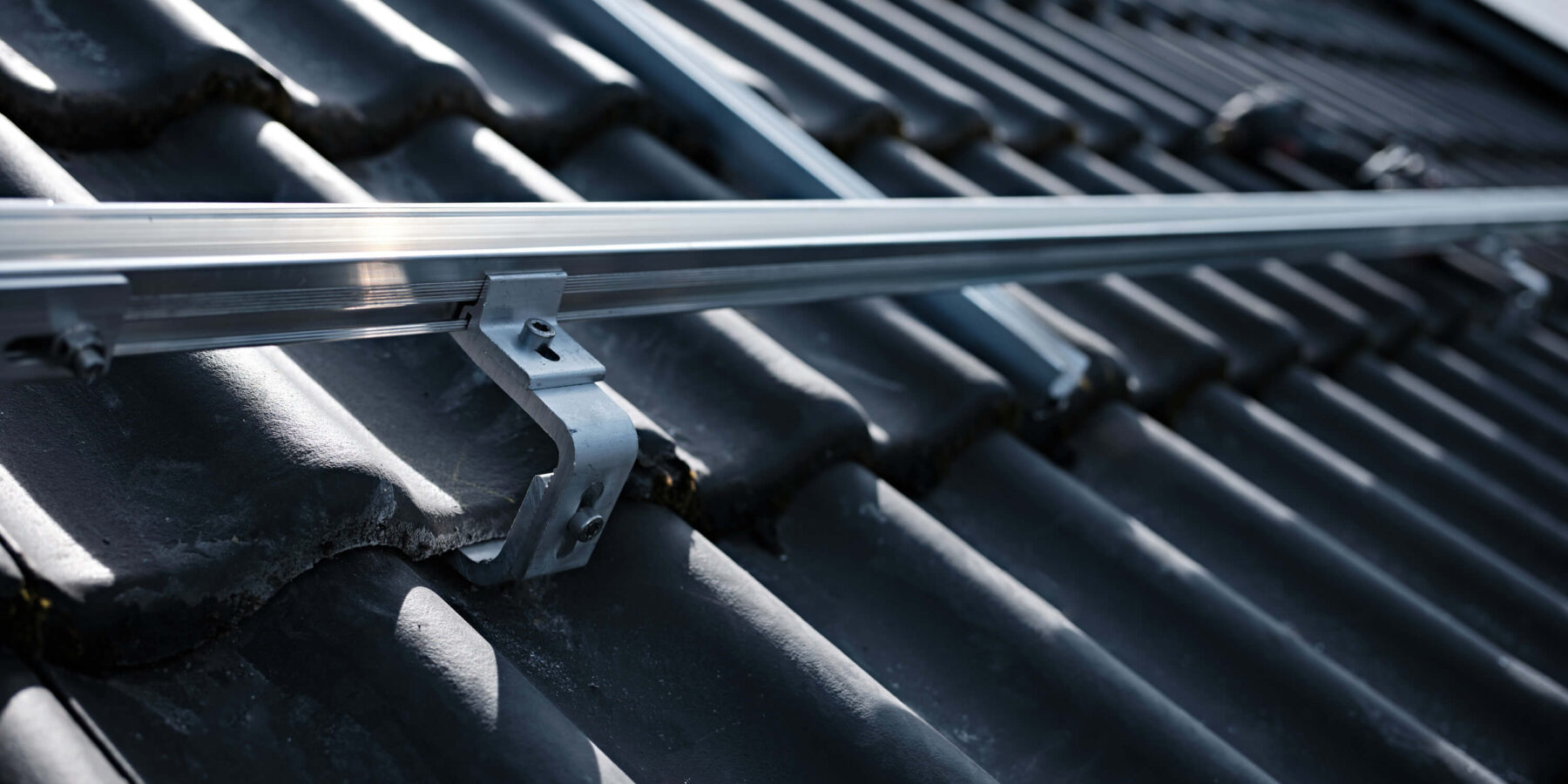 Dachhaken und Aluminiumschienen der Unterkonstruktion einer PV-Anlage